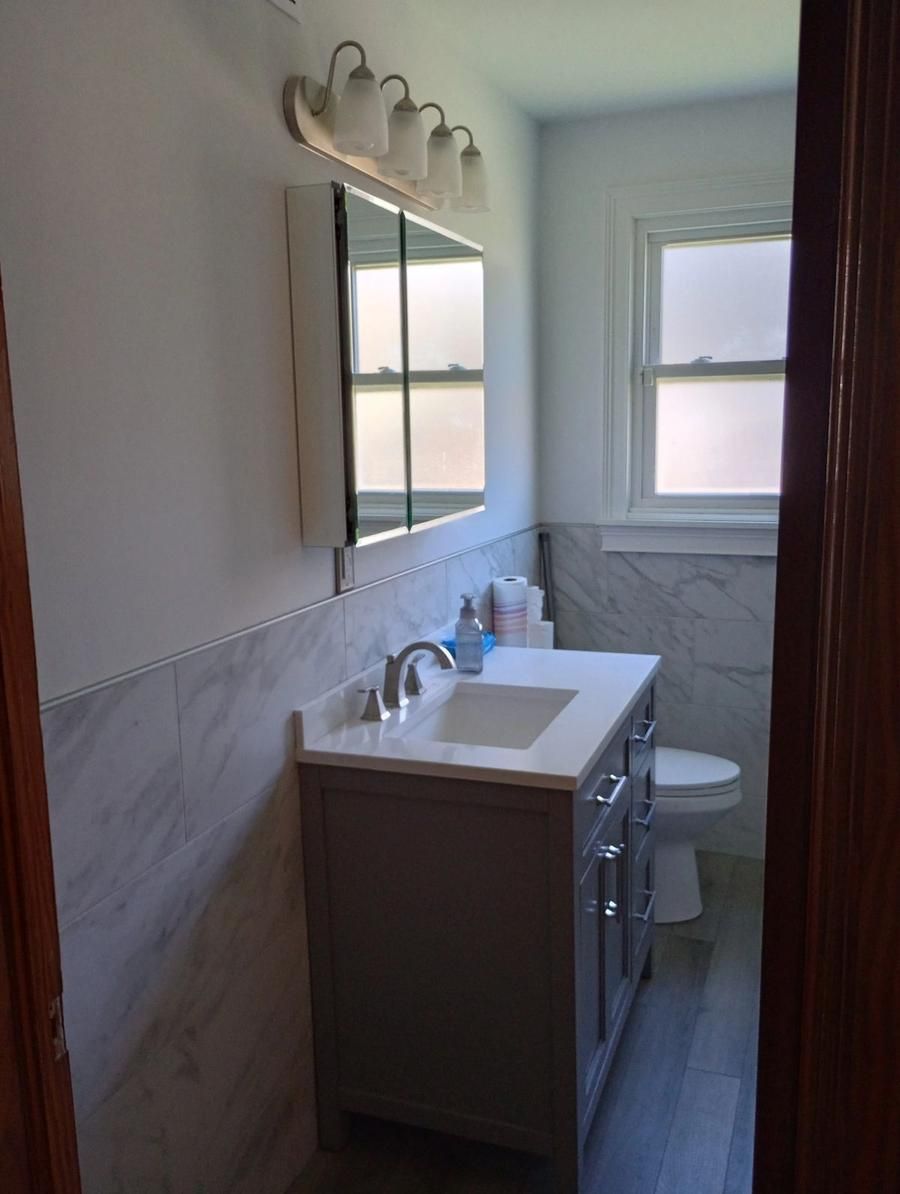 Bathroom remodel with marble tile and vanity