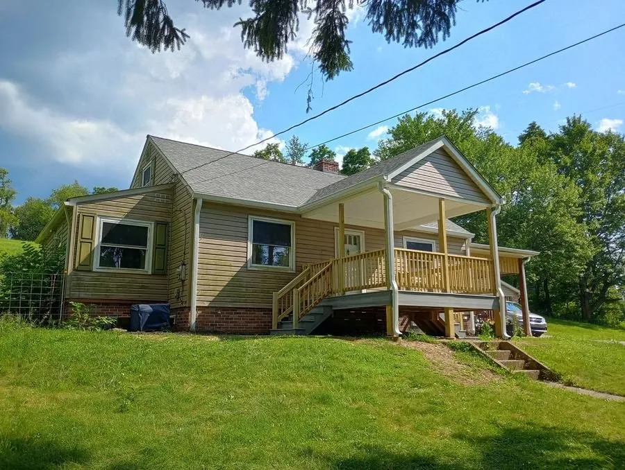 New covered front porch addition with wood railing and stairs, full exterior view