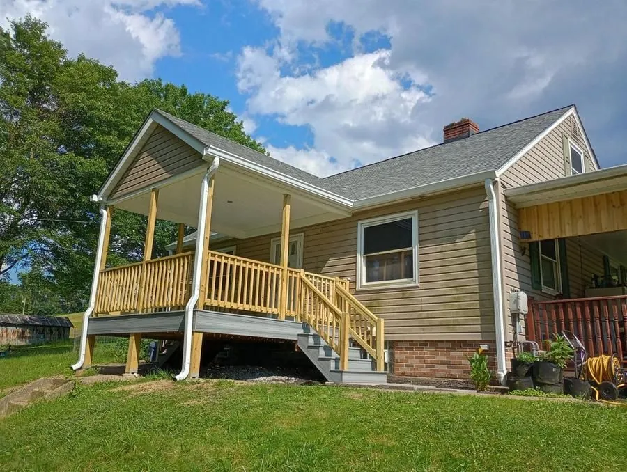 Covered porch addition with gabled roof, white fascia, and pressure-treated wood posts